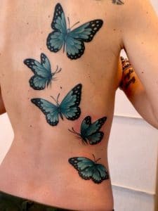 Tatouage femme papillon dos cote
